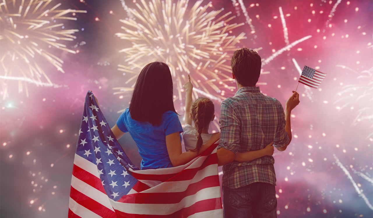 Family with USA flag watching fireworks safely