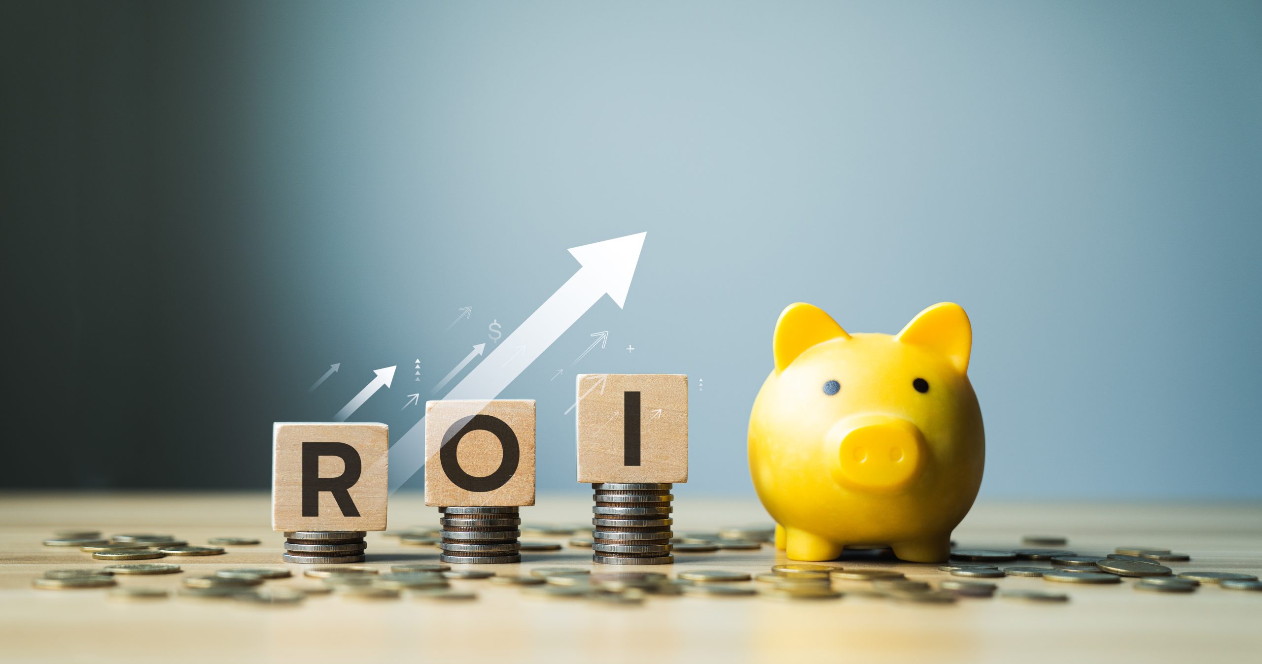 ROI concept with wooden blocks on stacked coins, yellow piggy bank, and upward financial growth arrows, symbolizing return on investment, financial success, and wealth accumulation